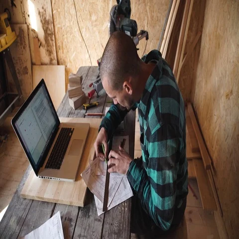 Young bold carpenter with moustache drawing in his workshop Stock Footage 69532717