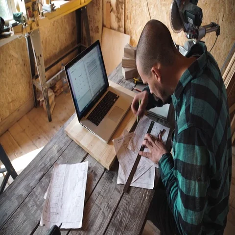 Young bold carpenter with moustache drawing in his workshop Stock Footage 69532779