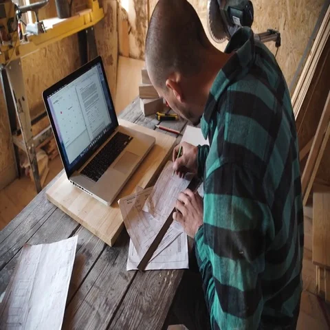 Young bold carpenter with moustache drawing in his workshop Stock Footage 69534892