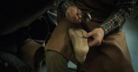 Young bootmaker drive in nails in a shoe at the private workshop. Video stock 246306699