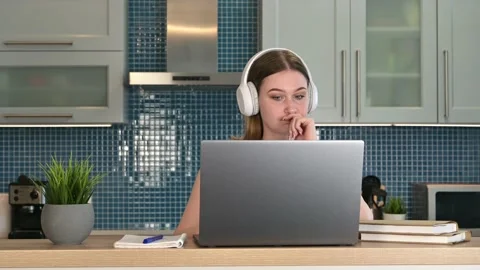 Young bored female student study in the kitchen using a laptop Stock Footage 198075566