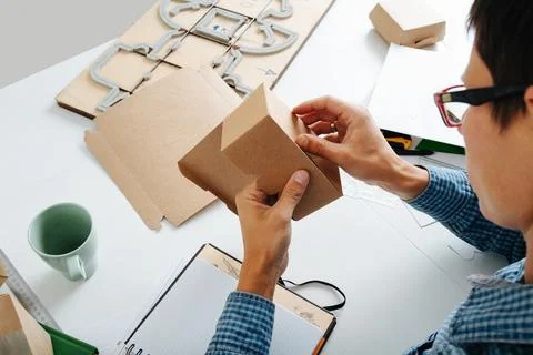 Young box designer looking at the folding of the product Foto stock