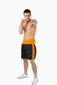 Young boxer with bare fists striking straight Stock Photos