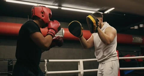 A young boxer practices punches with a trainer. Video stock 275276614