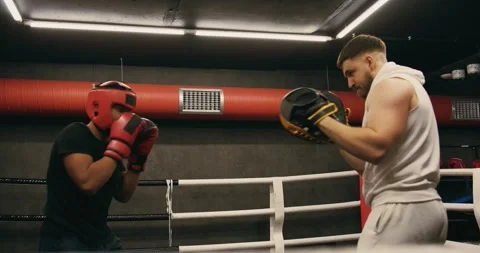 A young boxer practices punches with a trainer. Stock Footage 275276650