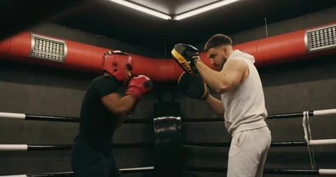 A young boxer practices punches with a trainer. Video stock 275276663