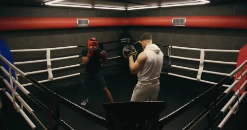 A young boxer practices punches with a trainer. Video stock 275276893