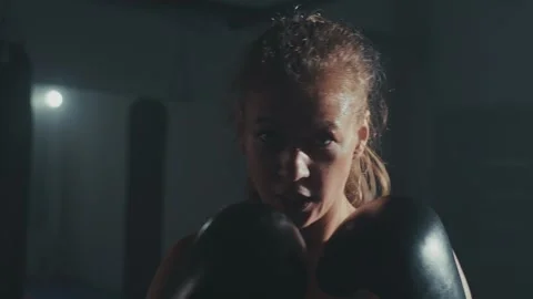 Young boxer practices techniques in dimly lit gym during early morning training Stock Footage 285150673
