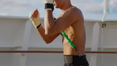 Young boxer starts box workout with resistance band training strap system Video stock 193884192