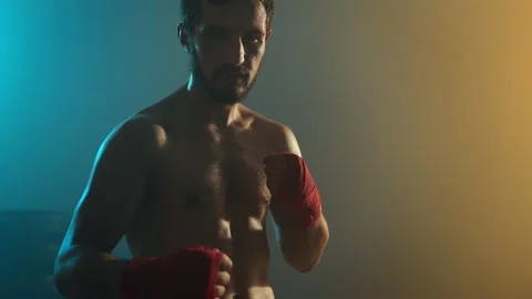 Young Boxer In Training. Handsome Man Looks Straight Into The Camera And Holds Stock Footage 160763104