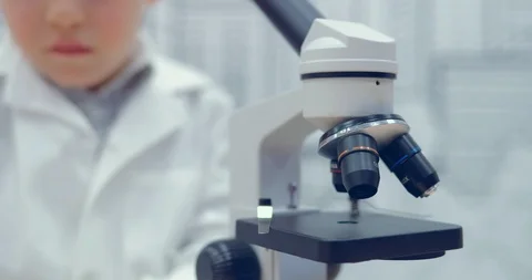 Young boy adjusts the microscope to work. Preparation of a workplace for Video stock 86151669