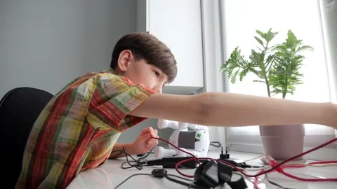 Young boy assembling robotics project at home Stock Footage 308438148