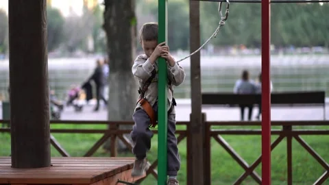 Young boy balancing on a rope obstacle course in a park, developing coordination 스톡 동영상 345936757
