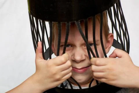 Young boy behind bars. The concept of confinement, restrictions. Isolated on  Stock Photos