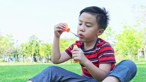 Young boy blowing bubble in park. Stock Footage 92236546
