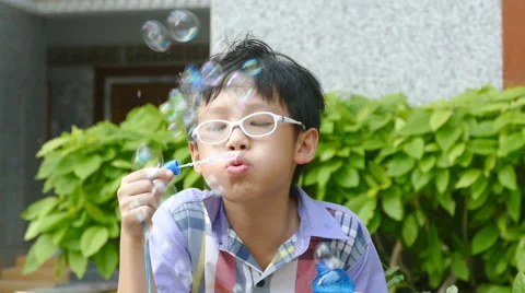 Young boy blowing bubbles Stock Footage 64107651