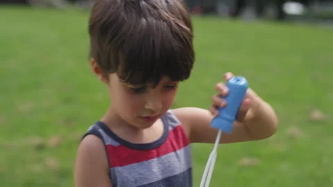 A young boy blows bubbles in a park on a summer day Video stock 143622976