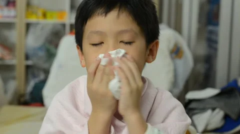 Young boy blows his nose Stock Footage 48735910