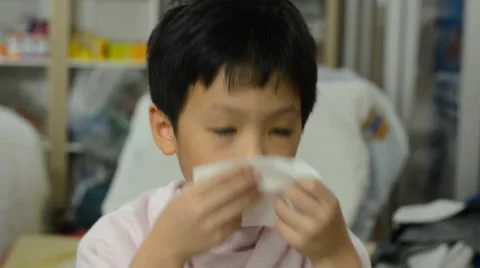 Young boy blows his nose Stock Footage 48750413