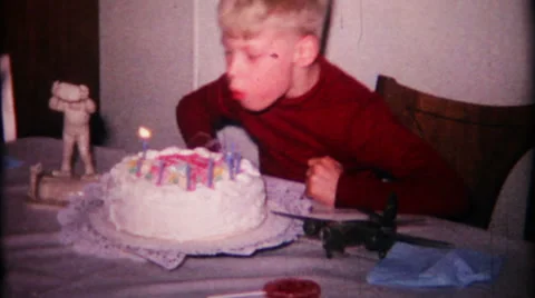 Young boy blows out candles on birthday cake 1950s vintage film home movie 156 Stock Footage 32274872
