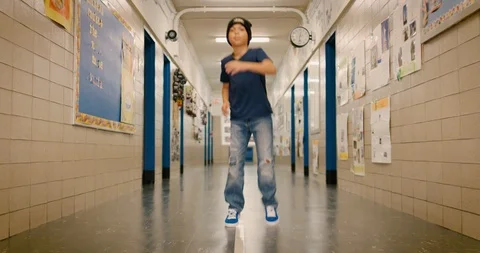 Young boy breakdancing in a school hallway Stock Footage 108784008