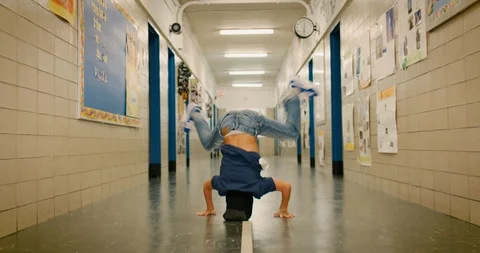 Young boy breakdancing in a school hallway Stock Footage 108784319