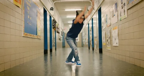 Young boy breakdancing in a school hallway Stock Footage 108784619