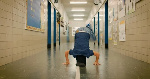 Young boy breakdancing in a school hallway Stock Footage 108784982