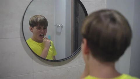 Young Boy Brushing His Teeth in The Bathroom Mirror Stock Footage 340291125