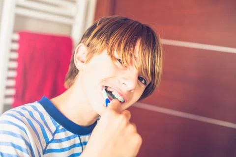 Young boy brushing his teeth on waking up in the bathroom New day of ordinary Stock Photos