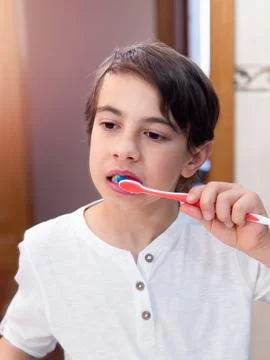 Young boy brushing teeth in bathroom Stock Photos