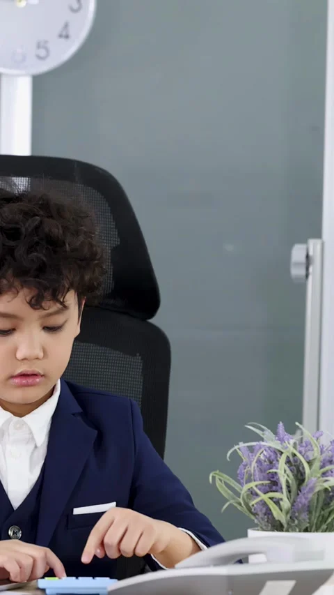 Young Boy in Business Suit Using Calculator at Office Desk Stock Footage 338437969
