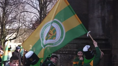 A young boy carrying the Glasgow-based GAA team, Tir Conaill Harps flag at the Видео 335319905