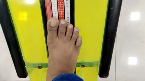 A young boy is checking his feet size in shoe sizes chart concept HD(4k) Video stock 221723960