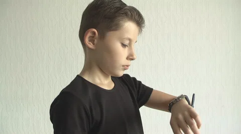Young boy checking his  for the time on his wrist watch. Stock Footage 68434195