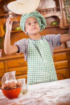 Young boy chef, throwing pizza dough into the air Stock Photos