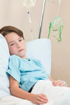 Young boy child patient in hospital bed Stock Photos