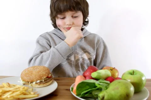 Young boy choosing vegetables and fruits instead of fast food Video stock 1163115