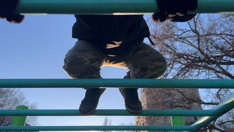 Young boy climbing monkey bars at playground Stock Footage 297005710