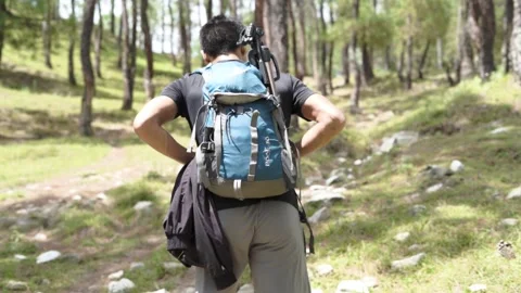 A young boy climbing the mountain with a backpack. Trekking and adventure. Stock-Footage 147091362