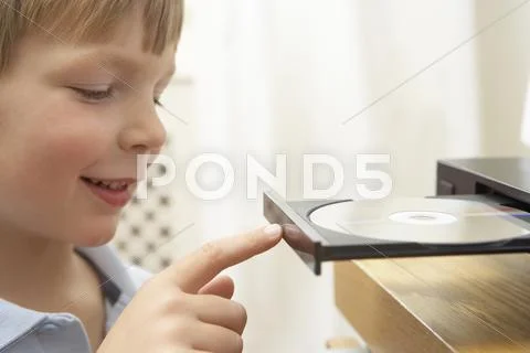 Young Boy Closing DVD Player With Finger Stock Photos