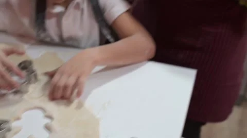 Young boy concentrated making christmas cookies with his family Stock Footage 324558560