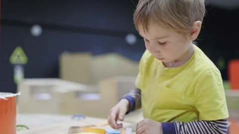 Young boy concentrating on a crafting project at a workshop Stock Footage 317820732
