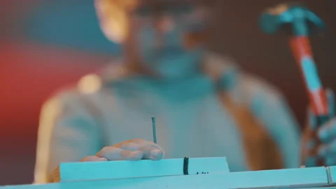 Young boy concentrating while hammering nail Stock Footage 329545068