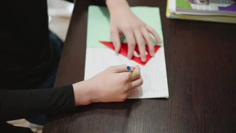 Young boy creates precise heart drawing with stencil. Child engaged in drawing Stock Footage 345148714