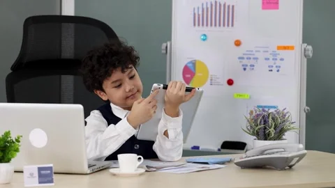 Young Boy with Curly Hair Using Tablet at Modern Office Desk Stock Footage 337086763