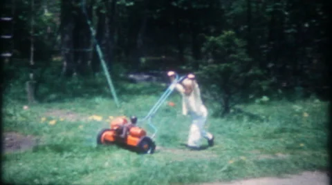 Young boy cuts the grass with power mower 1950s vintage film home movie 3298 Stock Footage 62960356