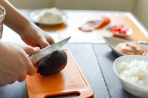 Young boy cutting avocado preparing sushi at home Stock Photos