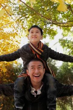 Young boy on dad's shoulders looking up Stock Photos