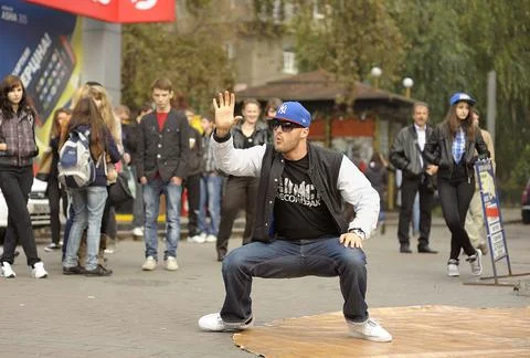 Young boy dancing break dance on the street, crowd of people watching. Octobe Stock Photos